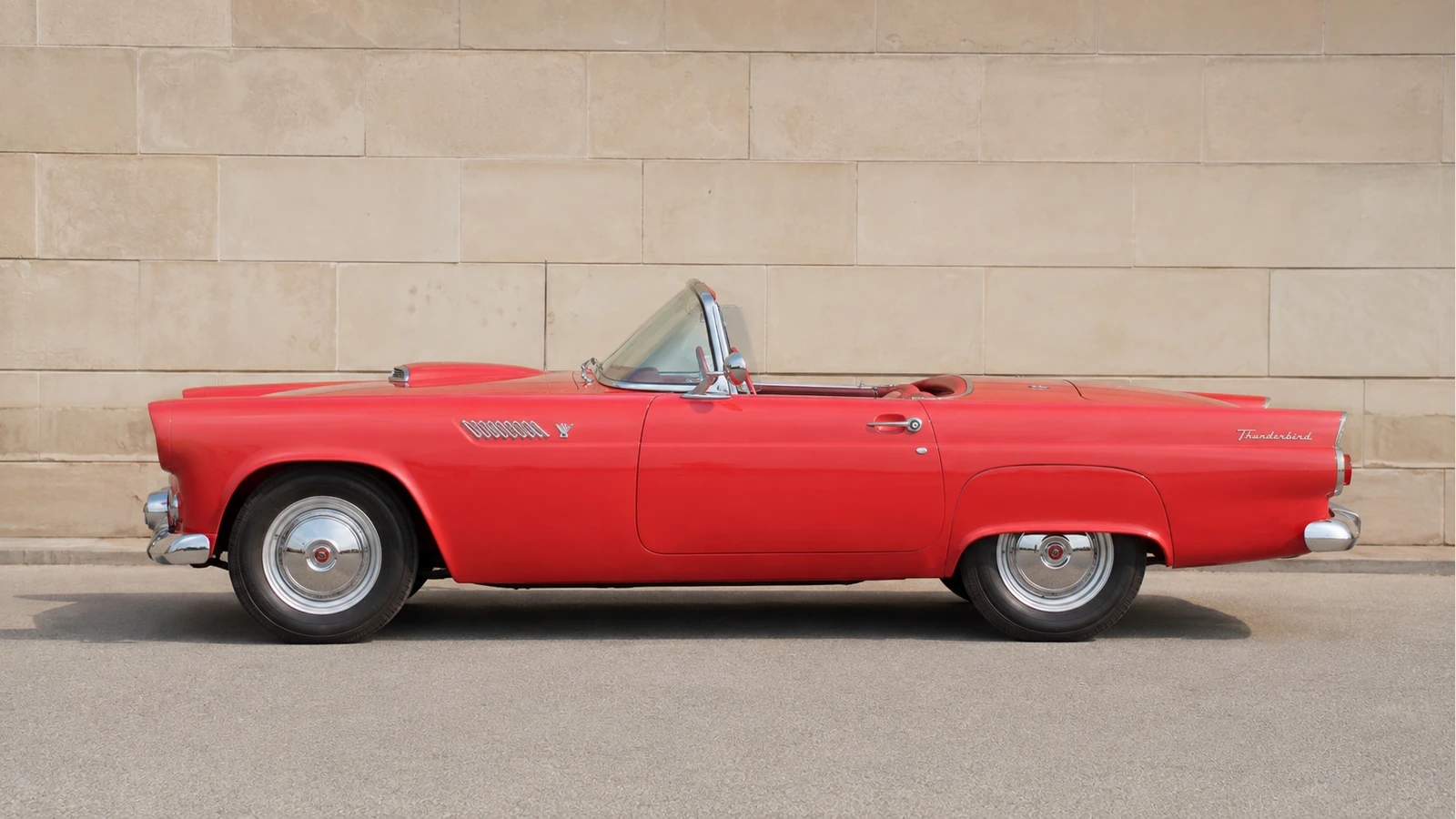 Красный Ford Thunderbird 1955 года с открытым верхом — профиль