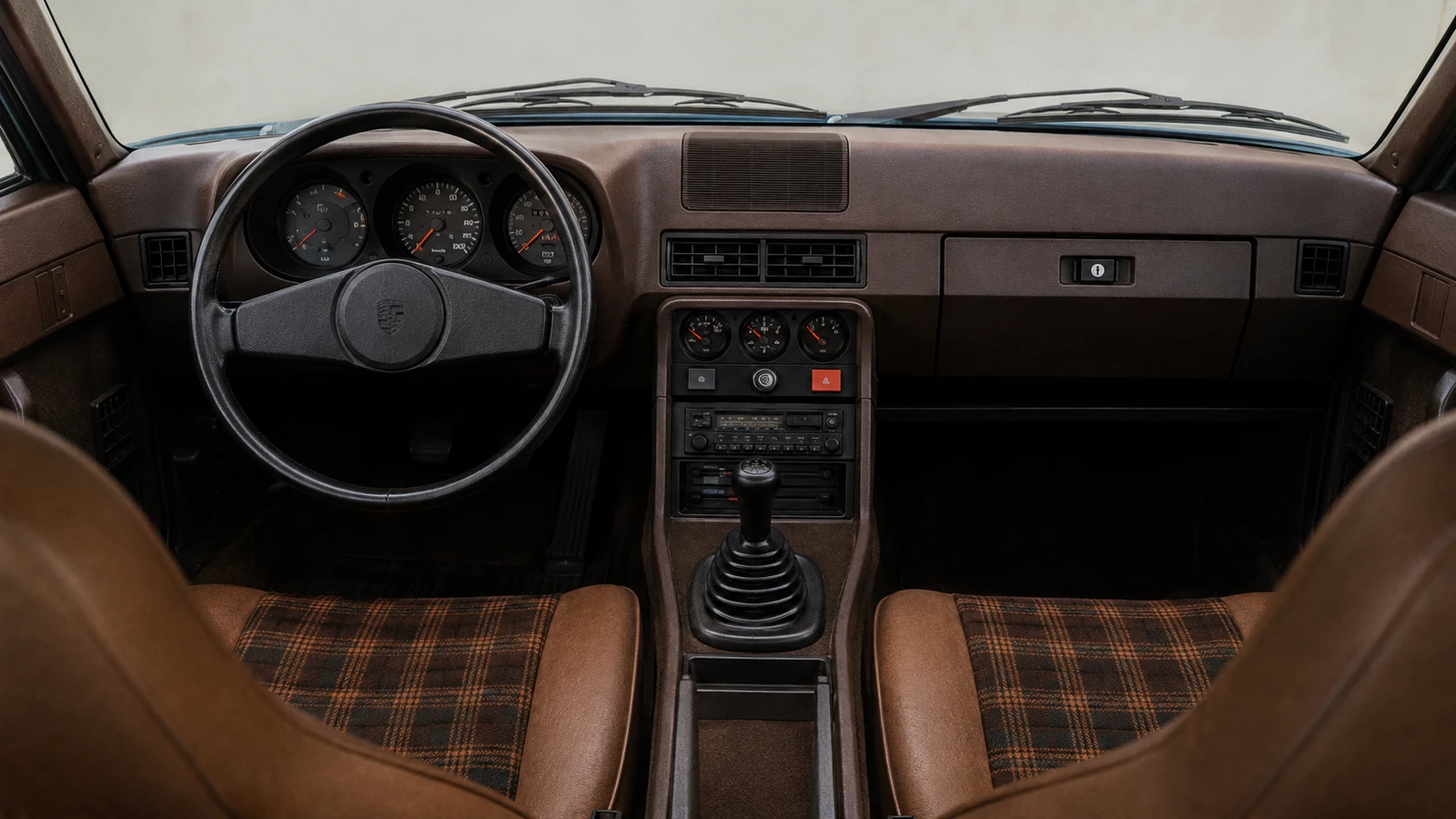 Коричневый салон Porsche 924 1976 года с тканью в клетку и двухспицевым рулём